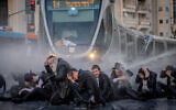 Police use a water cannon to disperse ultra-Orthodox demonstrators during an anti-conscription demonstration in Jerusalem, May 23, 2024. (Chaim Goldberg/Flash90)