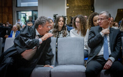 Supreme Court President Isaac Amit attempts to have a word with Justice Minister Yariv Levin who has boycotted the head of the judiciary ever since he took office, at a swearing- in ceremony for 35 new judges at the President's Residence in Jerusalem, April 10, 2025. (Chaim Goldberg/Flash90)