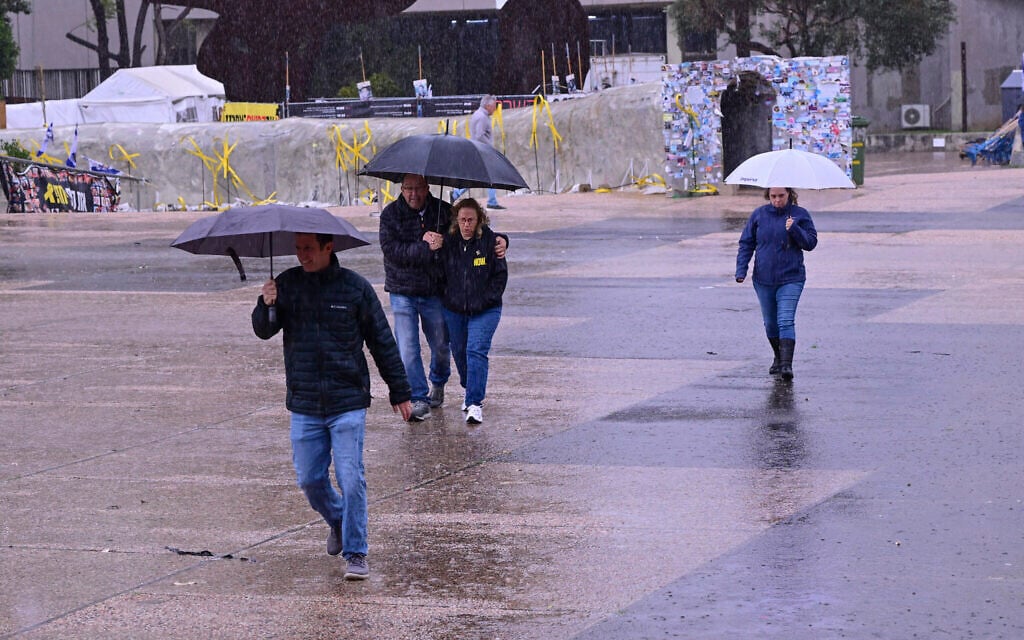 People walk in the rain at Hostages Square in Tel Aviv, January 9, 2026. (Avshalom Sassoni/Flash90)