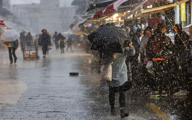 People walk in the rain at the Mahane Yehuda Market in Jerusalem, January 9, 2026 (Chaim Goldberg/Flash90) People walk in the rain at the Mahane Yehuda Market in Jerusalem, January 9, 2026 (Chaim Goldberg/Flash90)