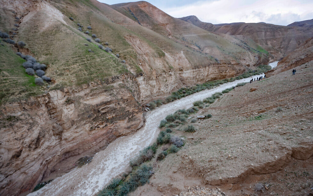 People watch flooding caused by rainwater in Nahal Og, a stream that runs from near Jerusalem to the Dead Sea, January 9, 2026. (Yossi Zamir/Flash90)