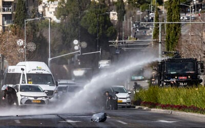 Ultra-Orthodox Jewish men block a road and clash with police during a protest against the planned autopsy of babies who died in a daycare, in Jerusalem, January 20, 2026. (Chaim Goldberg/Flash90)