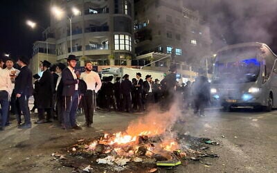 Haredim protesting against military conscription stand by a bonfire on a street in Jerusalem, January 6, 2026. (Sam Sokol/Times of Israel)