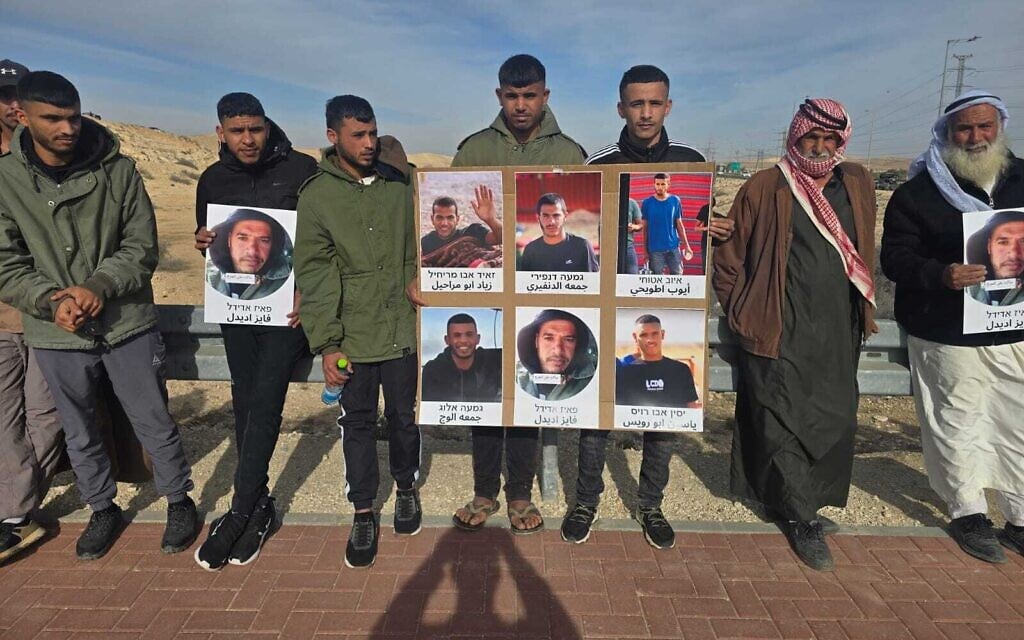 Protesters hold posters displaying the faces of men from the Bedouin village of Bir Hadaj who have been killed in recent years in what they characterize as extrajudicial killings, on January 1, 2026. (Courtesy)