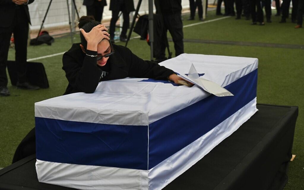 Shira Gvili embraces the coffin of her brother, Ran Gvili, at his funeral in Meitar, on January 28, 2026. (Uriel Even Sapir/Hostages and Missing Families Forum)