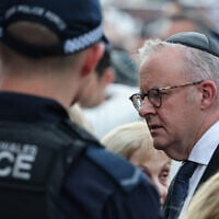 Australia's Prime Minister Anthony Albanese (right) wears a kippah as he arrives to attend the memorial held for the victims of a terror attack on a Hanukkah celebration at Bondi Beach in Sydney on December 21, 2025. (DAVID GRAY / AFP)
