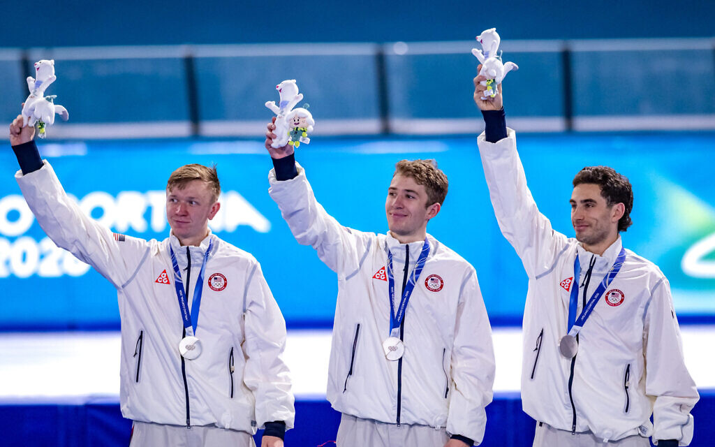 Emery Lehman, right, celebrates winning the silver medal with other members of his team in the three-man pursuit competition at the 2026 Winter Olympics in Milan, Italy, February 17, 2026. (Noel Stave/ Speedskating)