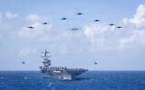 US Navy Carrier Air Wing 8 aircraft fly in formation over the world’s largest aircraft carrier, Ford-class aircraft carrier USS Gerald R. Ford (CVN 78), during Carrier Air Wing 8’s aerial change of command ceremony while underway in the Caribbean Sea, Jan. 19, 2026. (US Navy photo)