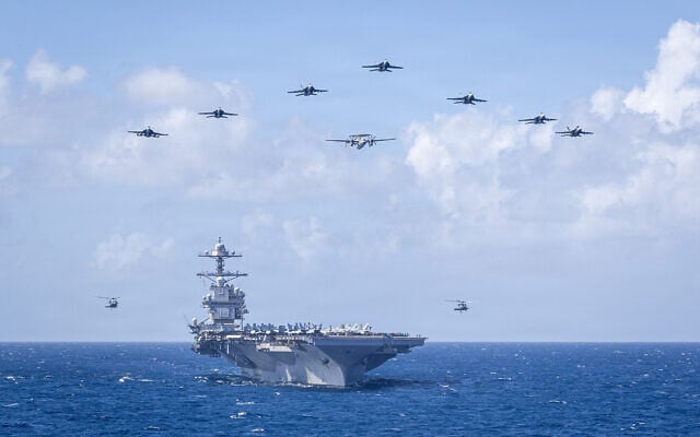 US Navy Carrier Air Wing 8 aircraft fly in formation over the world’s largest aircraft carrier, Ford-class aircraft carrier USS Gerald R. Ford (CVN 78), during Carrier Air Wing 8’s aerial change of command ceremony while underway in the Caribbean Sea, Jan. 19, 2026. (US Navy photo)