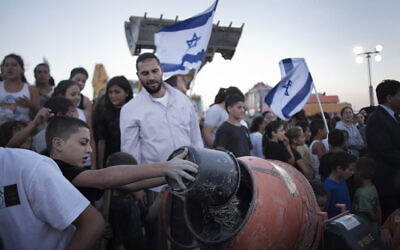 A Jewish boy throws water mixed with cement powder into a mixer in the Jewish Settlement of Adam, several kilometers from the West Bank city of Ramallah, as the Jewish residents symbolically resumed construction work on their settlement on September 1, 2010, in a defying move to protest the killing of four settlers by Palestinians near the West Bank town of Hebron the previous night. (MARCO LONGARI / AFP) A Jewish boy throws water mixed with cement powder into a mixer in the Jewish Settlement of Adam, several kilometers from the West Bank city of Ramallah, as the Jewish residents symbolically resumed construction work on their settlement on September 1, 2010, in a defying move to protest the killing of four settlers by Palestinians near the West Bank town of Hebron the previous night. (MARCO LONGARI / AFP)