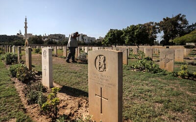 A gardener tends to the lawn between the tombstones at the Commonwealth Gaza War Cemetery -- commonly known as the British War Cemetery and in which are interred the remains of 3,217 Allied soldiers who died during World War I -- in Gaza City on September 28, 2022. (Mahmud HAMS / AFP)
