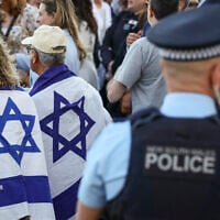 New South Wales police officers stand near members of the Australian Jewish community holding a memorial service for six Israeli hostages whose bodies were recovered from the Gaza Strip, at Sydney's Bondi Beach on September 2, 2024. (DAVID GRAY / AFP)