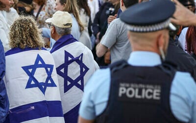 New South Wales police officers stand near members of the Australian Jewish community holding a memorial service for six Israeli hostages whose bodies were recovered from the Gaza Strip, at Sydney's Bondi Beach on September 2, 2024. (DAVID GRAY / AFP)