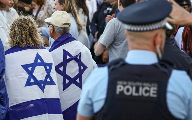New South Wales police officers stand near members of the Australian Jewish community holding a memorial service for six Israeli hostages whose bodies were recovered from the Gaza Strip, at Sydney's Bondi Beach on September 2, 2024. (DAVID GRAY / AFP)