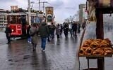 A street vendor sells traditional Turkish bagels "Simit" as he waits for customers at Taksim Square, in Istanbul, on December 27, 2025. (Yasin Akgul/AFP)