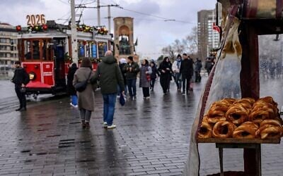 A street vendor sells traditional Turkish bagels "Simit" as he waits for customers at Taksim Square, in Istanbul, on December 27, 2025. (Yasin Akgul/AFP)