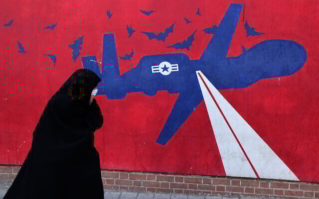 زنی در حال عبور از کنار نقاشی دیواری پهپاد آمریکایی در تهران