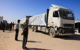 Palestinians look on as trucks carrying humanitarian aid arrive in Khan Younis in the southern Gaza Strip on February 1, 2026. (Bashar Taleb / AFP)