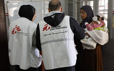 A Palestinian woman arrives with a child at the Doctors Without Borders or Medecins Sans Frontieres (MSF) clinic, in the al-Rimal neighborhood of Gaza City on December 31, 2025. (Omar AL-QATTAA / AFP)