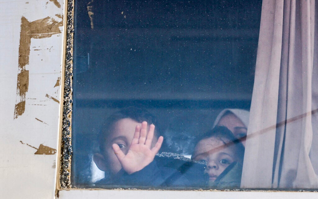 Palestinian children with a family member look out of the window of a bus transporting patients toward the Kerem Shalom crossing to leave the Gaza Strip for treatment abroad, in Khan Younis in the southern Gaza Strip, on February 2, 2026 (Bashar Taleb / AFP)