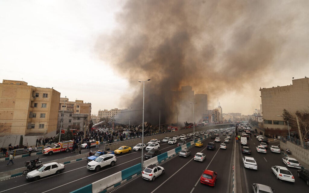 Motorists drive past as firefighters battle a fire that broke out in Jannat Bazaar, west of Tehran on February 3, 2026. (Photo by ATTA KENARE / AFP) Motorists drive past as firefighters battle a fire that broke out in Jannat Bazaar, west of Tehran on February 3, 2026. (Photo by ATTA KENARE / AFP)