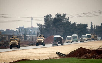 US military vehicles move along a road in a convoy transporting Islamic State group detainees being transferred to Iraq from Syria, on the outskirts of Qahtaniyah in Syria's northeastern Hasakah province on February 7, 2026. (Delil SOULEIMAN / AFP)