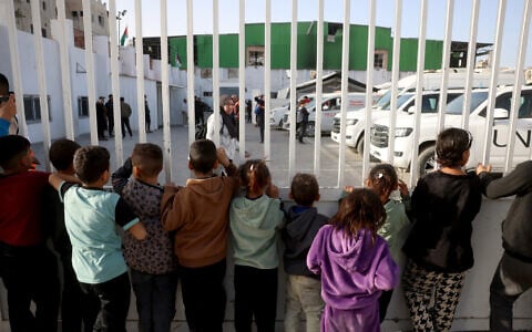 Palestinian children watch as patients prepare to leave the Gaza Strip for treatment through the Rafah border crossing between the Gaza Strip and Egypt after it was opened by Israel for a limited number of people, in Khan Younis in the southern Gaza Strip, on February 8, 2026. (Bashar Taleb/ AFP)