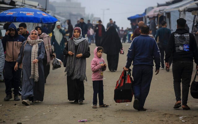 Palestinians walk down a road in Khan Younis, in the southern Gaza Strip, on February 10, 2026. (BASHAR TALEB / AFP)