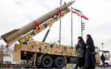 Women walk past a ballistic missile launch vehicle in Tehran on February 11, 2026, during a rally marking the 47th anniversary of the 1979 Islamic revolution (AFP)