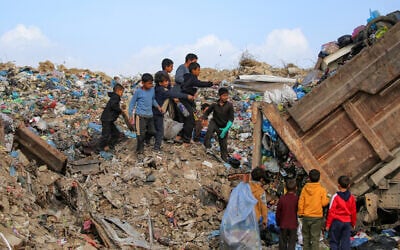 Children sort through waste at a trash mound at the Maghazi camp for Palestinian refugees in the central Gaza Strip on February 11, 2026. (Eyad BABA / AFP)