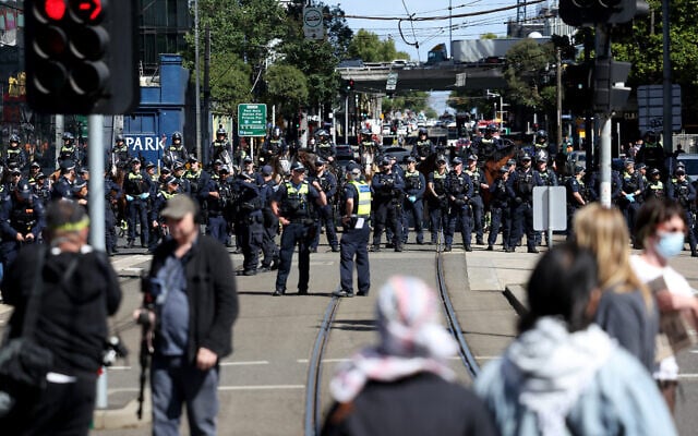 Protesters stand in front of police officers as they cordon off an intersection during the visit of President Isaac Herzog in Melbourne on February 12, 2026. (MARTIN KEEP / AFP) Protesters stand in front of police officers as they cordon off an intersection during the visit of President Isaac Herzog in Melbourne on February 12, 2026. (MARTIN KEEP / AFP)