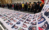 Protesters display a banner featuring portraits of alleged victims of the Iranian government during a demonstration against the Iranian government called by the People's Mujahedin of Iran (MEK), in Munich, southern Germany, on the sidelines of the 62nd Munich Security Conference (MSC) on February 13, 2026. (Michaela STACHE / AFP)