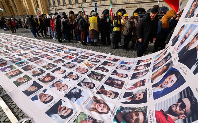 Protesters display a banner featuring portraits of alleged victims of the Iranian government during a demonstration against the Iranian government called by the People's Mujahedin of Iran (MEK), in Munich, southern Germany, on the sidelines of the 62nd Munich Security Conference (MSC) on February 13, 2026. (Michaela STACHE / AFP) Protesters display a banner featuring portraits of alleged victims of the Iranian government during a demonstration against the Iranian government called by the People's Mujahedin of Iran (MEK), in Munich, southern Germany, on the sidelines of the 62nd Munich Security Conference (MSC) on February 13, 2026. (Michaela STACHE / AFP)