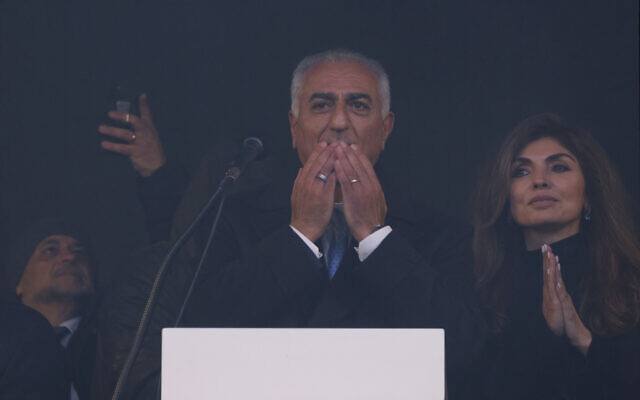 Iran's former crown prince and key opposition figure Reza Pahlavi (C) stands behind a glass pane on stage next to his wife Yasmine Pahlavi during a demonstration of the Iranian opposition on February 14, 2026 at the Theresienwiese fair grounds in Munich, southern Germany. (Michaela STACHE / AFP) Iran's former crown prince and key opposition figure Reza Pahlavi (C) stands behind a glass pane on stage next to his wife Yasmine Pahlavi during a demonstration of the Iranian opposition on February 14, 2026 at the Theresienwiese fair grounds in Munich, southern Germany. (Michaela STACHE / AFP)