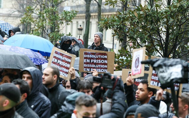 Demonstrators hold placards reading "Jeune Garde - an antifascist group - dissolution, Jeune Garde in jail" as they attend a rally after the fatal beating in Lyon of a 23-year-old Quentin, in Paris on February 15, 2026. French President Emmanuel Macron on February 14, 2026 urged calm and restraint after the fatal beating of a 23-year-old French youth aligned with the far-right on the sidelines of a conference by a hard-left lawmaker in the southeastern city of Lyon. The death of the young man -- identified only as Quentin -- has intensified tensions between France's far-right and hard-left who are both eyeing 2027 presidential elections. (Photo by Alain JOCARD / AFP) Demonstrators hold placards reading "Jeune Garde - an antifascist group - dissolution, Jeune Garde in jail" as they attend a rally after the fatal beating in Lyon of a 23-year-old Quentin, in Paris on February 15, 2026. French President Emmanuel Macron on February 14, 2026 urged calm and restraint after the fatal beating of a 23-year-old French youth aligned with the far-right on the sidelines of a conference by a hard-left lawmaker in the southeastern city of Lyon. The death of the young man -- identified only as Quentin -- has intensified tensions between France's far-right and hard-left who are both eyeing 2027 presidential elections. (Photo by Alain JOCARD / AFP)