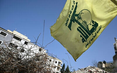 A Hezbollah flag flutters above the rubble of a building that was hit in January by an Israeli strike in the southern Lebanese village of Qannarit, on February 16, 2026. (Joseph EID / AFP)