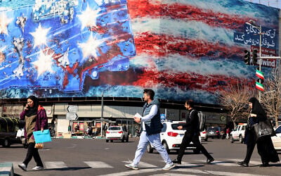 Iranians walk past an anti-US billboard installed on a building on Enqelab Square in Tehran on February 17, 2026. (ATTA KENARE / AFP) Iranians walk past an anti-US billboard installed on a building on Enqelab Square in Tehran on February 17, 2026. (ATTA KENARE / AFP)