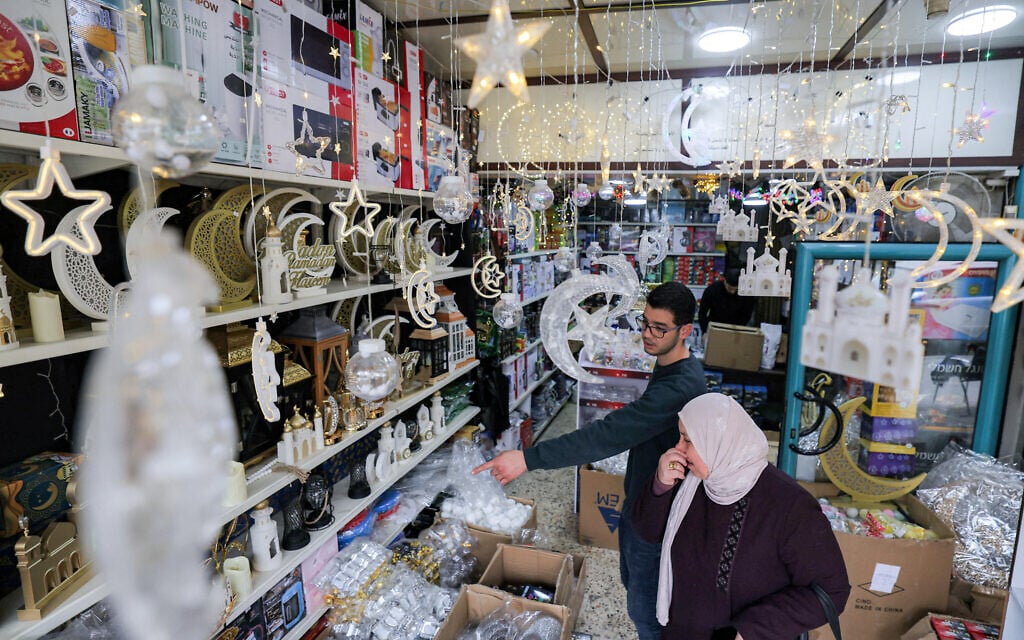 A vendor assists a woman to pick Ramadan decorations at a shop in the West Bank city of Hebron on February 17,2026 as Muslims prepare ahead of the holy fasting month of Ramadan (HAZEM BADER / AFP)