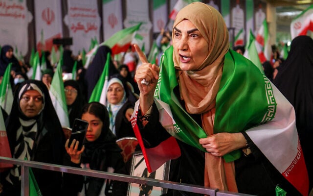 A woman draped in the Iranian flag confronts with protests the government spokesperson attending a memorial ceremony marking the 40th day of mourning for victims killed in previous anti-government protests in Iran, at the Tehran Musalla on February 17, 2026. (ATTA KENARE / AFP) A woman draped in the Iranian flag confronts with protests the government spokesperson attending a memorial ceremony marking the 40th day of mourning for victims killed in previous anti-government protests in Iran, at the Tehran Musalla on February 17, 2026. (ATTA KENARE / AFP)