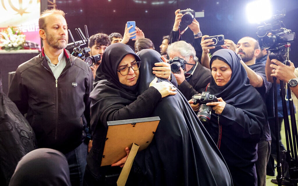 Iran's government spokesperson Fatemeh Mohajerani (center left) embraces the relative of a victim during a memorial ceremony marking the 40th day of mourning for victims killed in anti-government protests in Iran, at the Tehran Musalla on February 17, 2026. (ATTA KENARE / AFP)