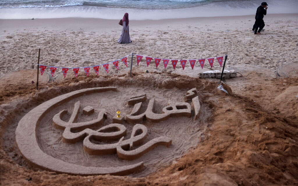 People walk past a sand sculpture with the greeting message Welcome, Ramadan' created by Palestinian artist Yazeed Abu Jarad at beach in Khan Younis in the south of the Gaza Strip on February 17, 2026 (Bashar Taleb / AFP) People walk past a sand sculpture with the greeting message Welcome, Ramadan' created by Palestinian artist Yazeed Abu Jarad at beach in Khan Younis in the south of the Gaza Strip on February 17, 2026 (Bashar Taleb / AFP)