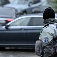 A Swiss police officer stands as diplomatic delegation cars arrive outside the hotel for a second day of US-mediated talks with Russia and Ukraine seeking to find an end to the four-year war, in Geneva on February 18, 2026 (Harold CUNNINGHAM / AFP)