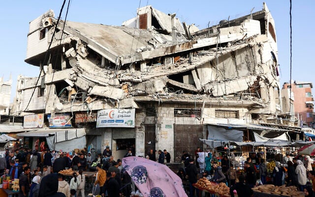 Palestinians shop for food beneath a destroyed building in Gaza City's Zawiya market on February 18, 2026, on the first days of the holy fasting month of Ramadan. (Omar AL-QATTAA / AFP) Palestinians shop for food beneath a destroyed building in Gaza City's Zawiya market on February 18, 2026, on the first days of the holy fasting month of Ramadan. (Omar AL-QATTAA / AFP)