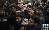 Mourners carry the body of Palestinian-American Nasrallah Muhammad Abu Siam, 19, February 19, 2026, who was allegedly shot by settlers, during his funeral in the West Bank village of Mukhmas, east of Ramallah. (Photo by JOHN WESSELS / AFP)