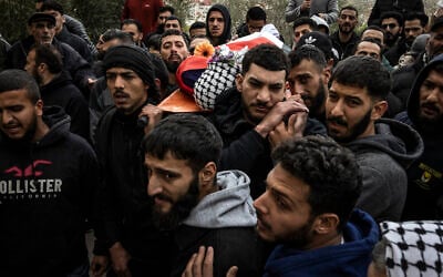 Mourners carry the body of Palestinian-American Nasrallah Muhammad Abu Siam, 19, February 19, 2026, who was allegedly shot by settlers, during his funeral in the West Bank village of Mukhmas, east of Ramallah. (Photo by JOHN WESSELS / AFP)