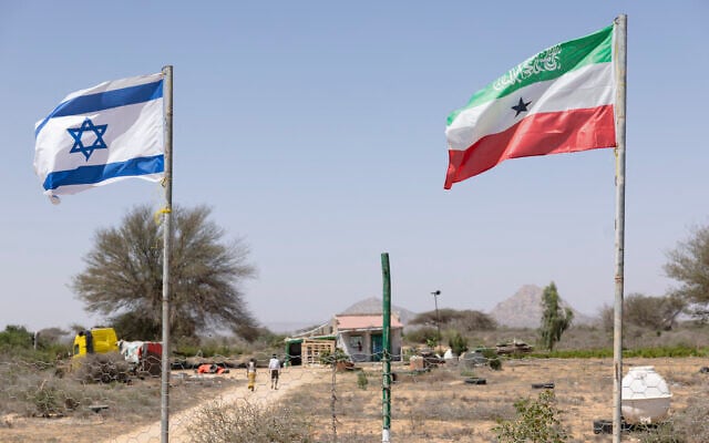 People walk by the flags of Israel and Somaliland flying alongside each other at the entrance to a fruit farm between the Somaliland capital city of Hargeisa and port city of Berbera along the highway connecting the two as Muslims commemorate the holy month of Ramadan on February 19, 2026. (Tony KARUMBA / AFP) People walk by the flags of Israel and Somaliland flying alongside each other at the entrance to a fruit farm between the Somaliland capital city of Hargeisa and port city of Berbera along the highway connecting the two as Muslims commemorate the holy month of Ramadan on February 19, 2026. (Tony KARUMBA / AFP)