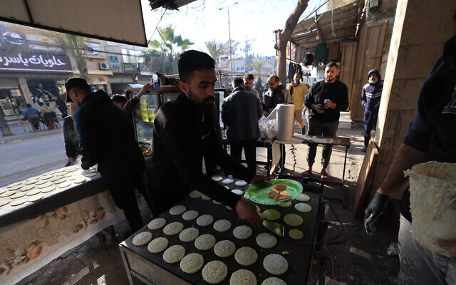 A displaced Palestinian prepares to sell a popular dessert qatayef during the holy month of Ramadan, at a corner market in an attempt to overcome harsh living conditions in Nuseirat in the central Gaza Strip, on February 20, 2026. (Eyad Baba / AFP)