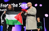 Syrian-Palestinian director Abdullah Al-Khatib (L) and Algerian producer Taqiyeddine Issaad hold a Palestinian flag as they accept the GWFF Best Feature Film Debut Award for "Chronicles From the Siege" during the Award Ceremony of the 76th Berlinale, Europe's first major film festival of the year, in Berlin on February 21, 2026. (RALF HIRSCHBERGER / AFP)