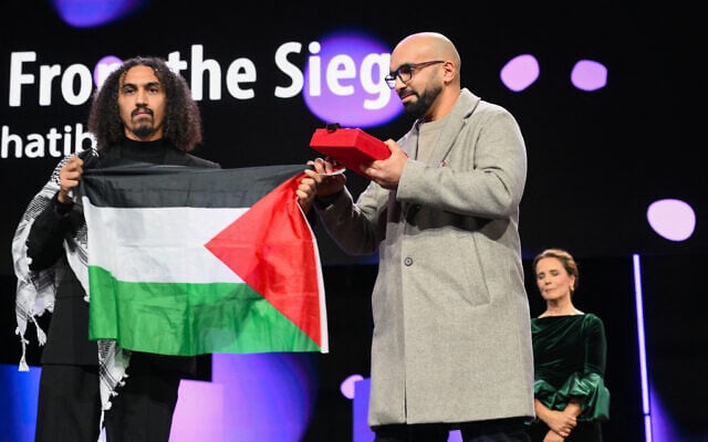 Syrian-Palestinian director Abdullah Al-Khatib (L) and Algerian producer Taqiyeddine Issaad hold a Palestinian flag as they accept the GWFF Best Feature Film Debut Award for "Chronicles From the Siege" during the Award Ceremony of the 76th Berlinale, Europe's first major film festival of the year, in Berlin on February 21, 2026. (RALF HIRSCHBERGER / AFP) Syrian-Palestinian director Abdullah Al-Khatib (L) and Algerian producer Taqiyeddine Issaad hold a Palestinian flag as they accept the GWFF Best Feature Film Debut Award for "Chronicles From the Siege" during the Award Ceremony of the 76th Berlinale, Europe's first major film festival of the year, in Berlin on February 21, 2026. (RALF HIRSCHBERGER / AFP)