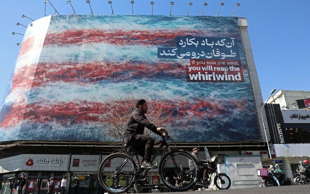 A cyclist rides past an anti-US billboard installed on a building along a street in Tehran, Iran, on February 26, 2026. (AFP) A cyclist rides past an anti-US billboard installed on a building along a street in Tehran, Iran, on February 26, 2026. (AFP)